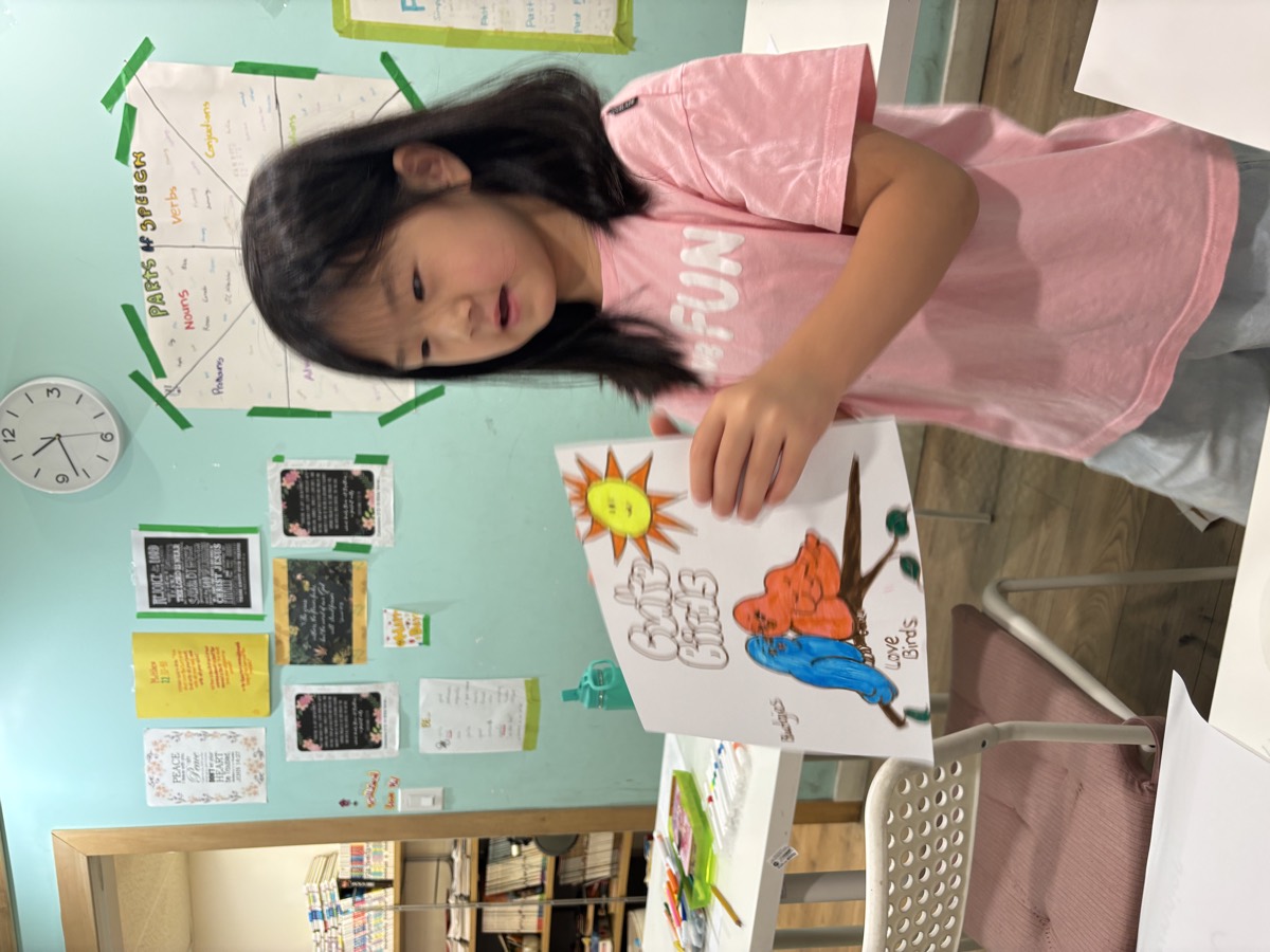A girl presenting her Cute Birds poster to the class