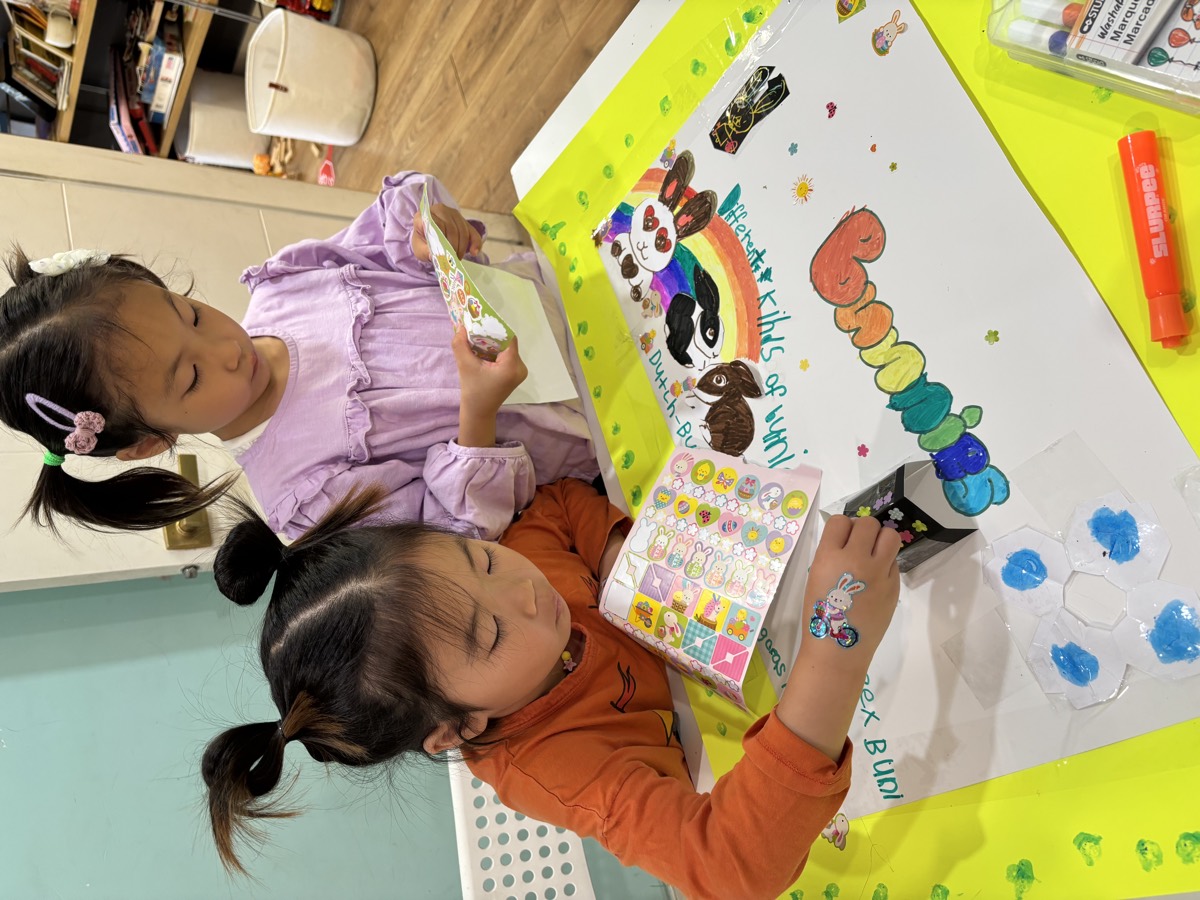 Two young girls working together on their bunnies poster