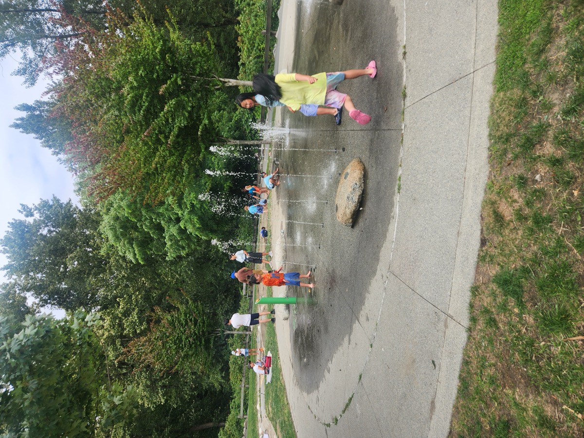 Kids playing between the water jets at the splash pad