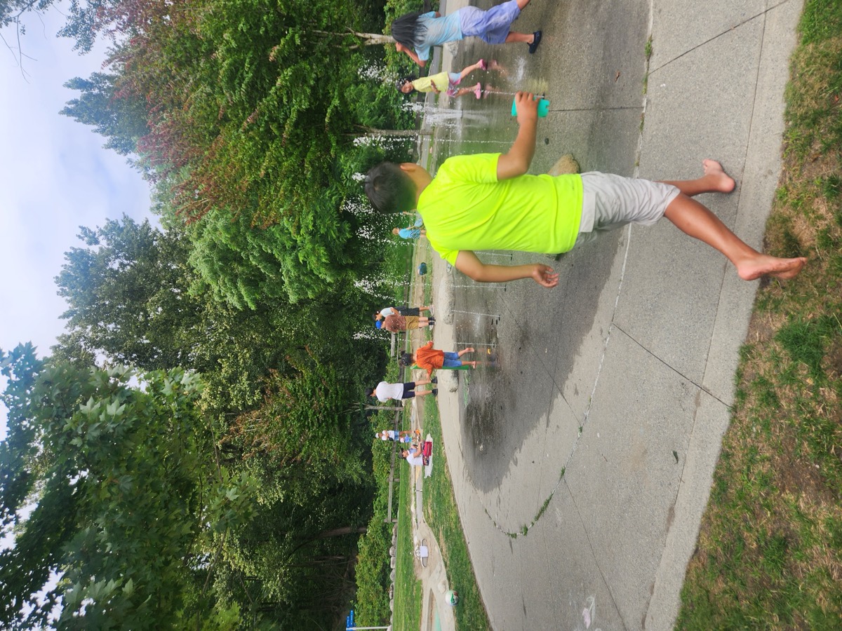 A boy running barefoot through the spray