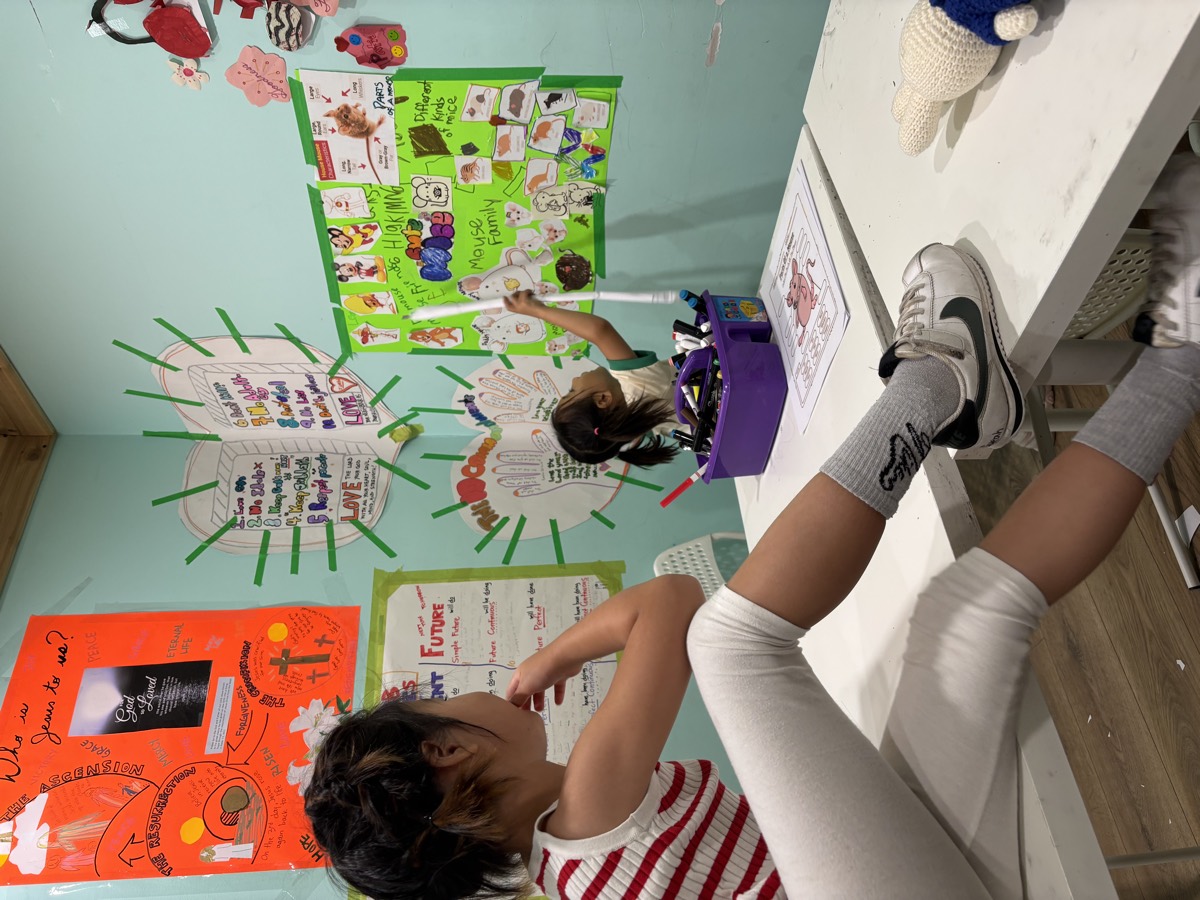 A student watching from her seat as Leah points at the mouse poster