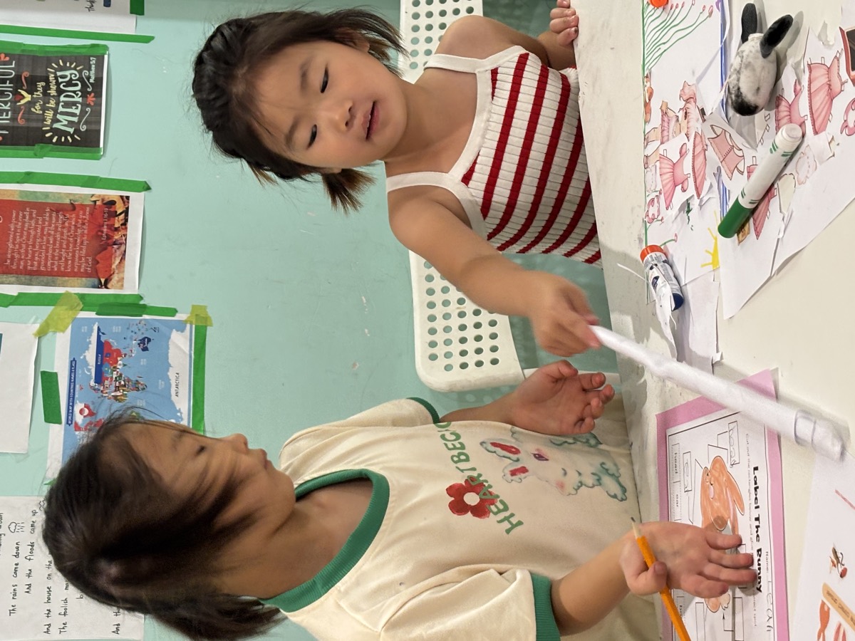 Leah giving instructions to a student working on her worksheet