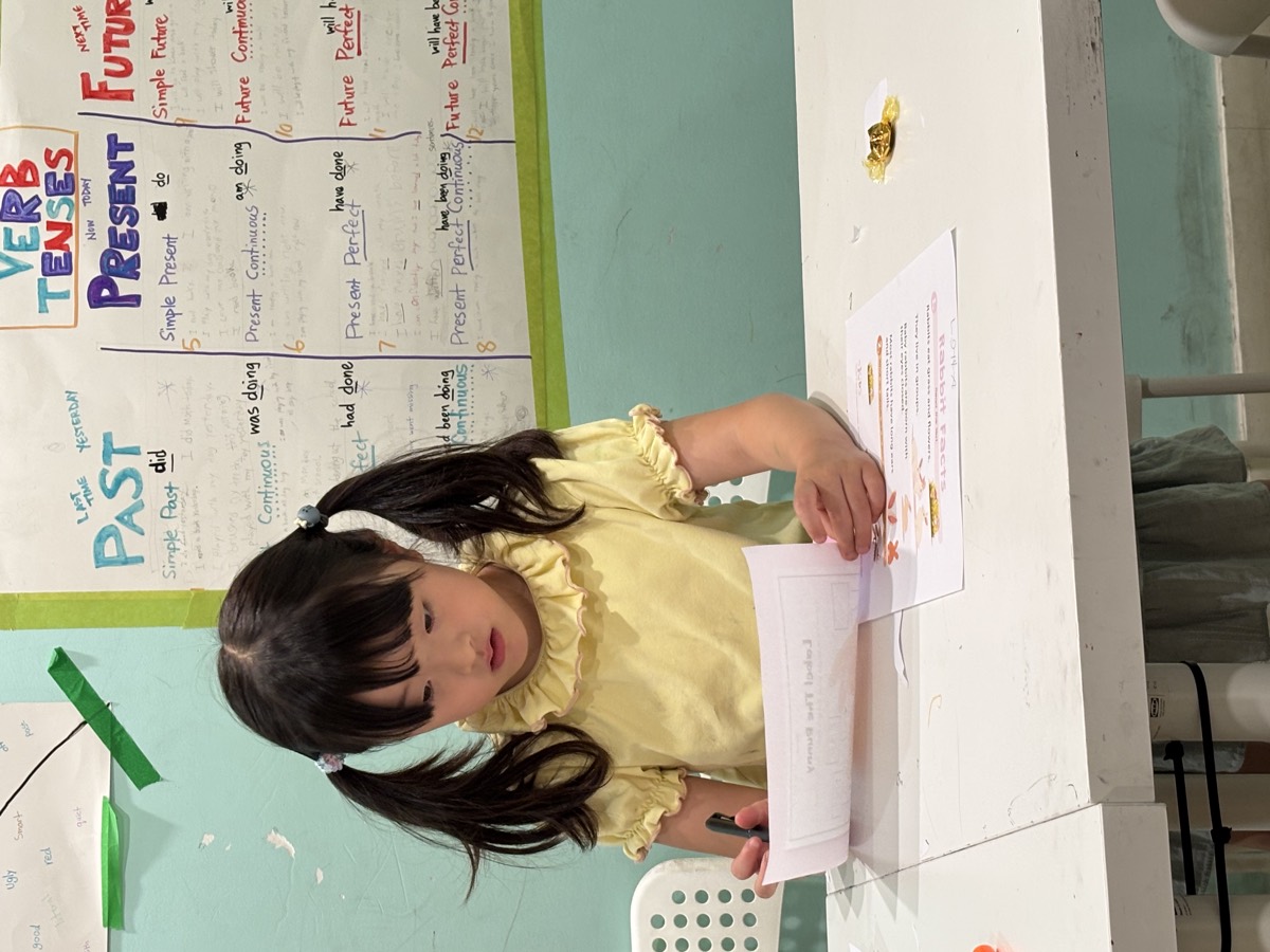 A student standing and reading her Rabbit Facts worksheet aloud
