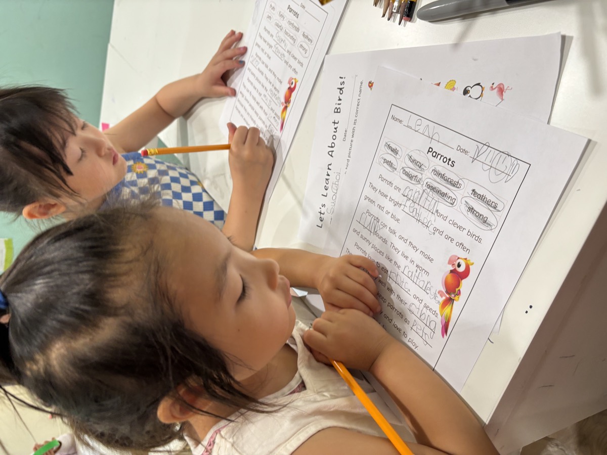 Two young students working on the Let's Learn About Birds worksheet