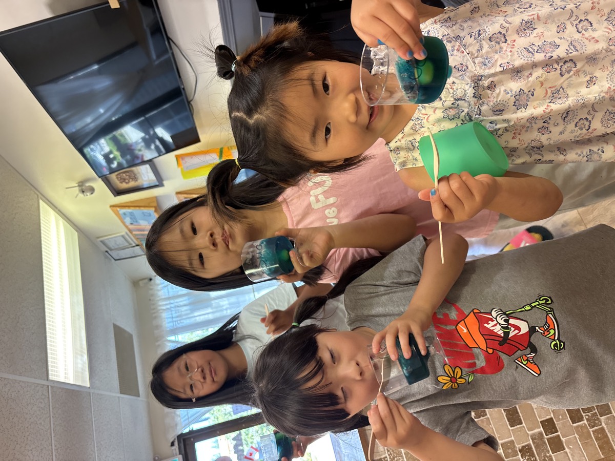 Four girls smiling and holding up their cups of homemade blueberry jelly
