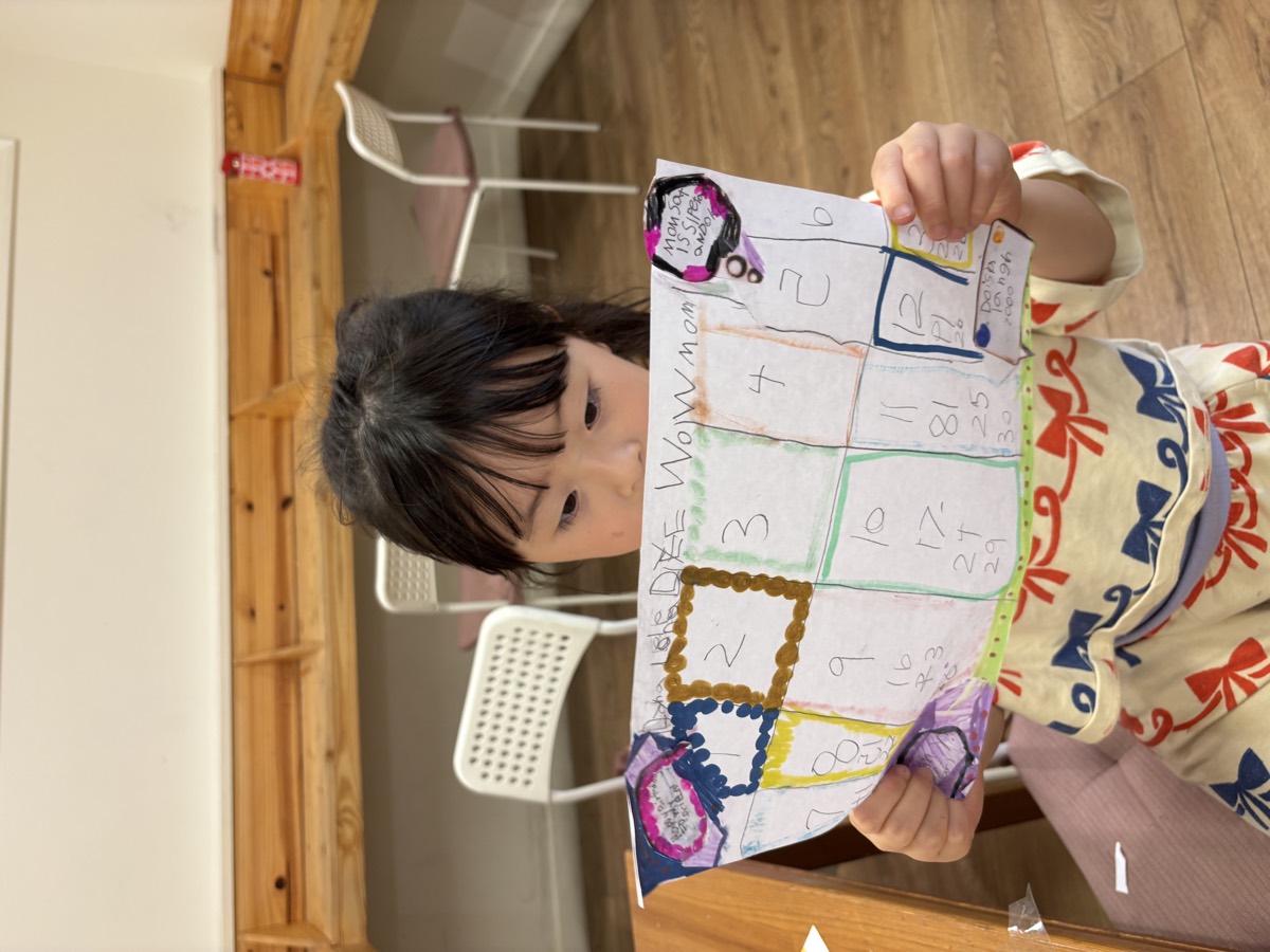 A student holding up her hand-drawn calendar covered in numbered boxes and speech bubbles