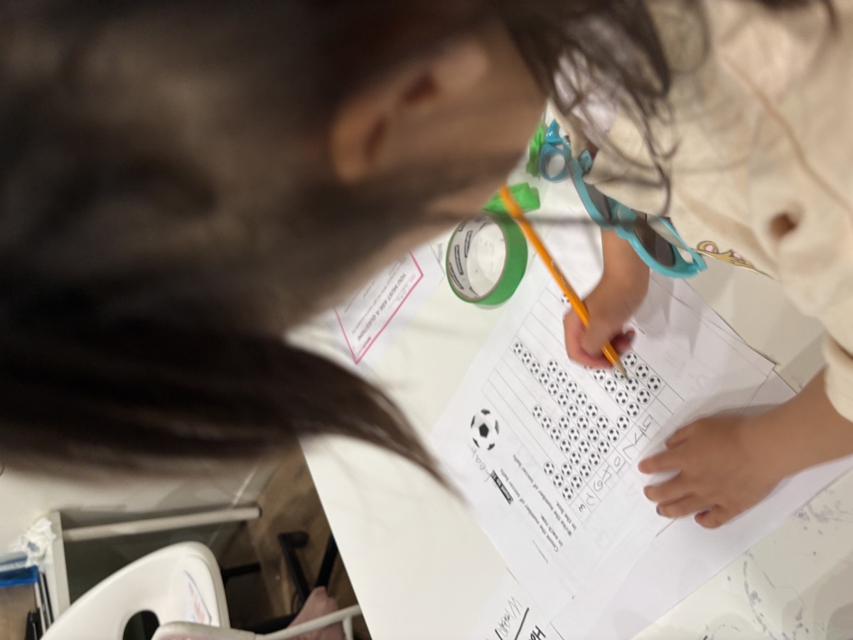 A young student concentrating on her worksheet with a pencil