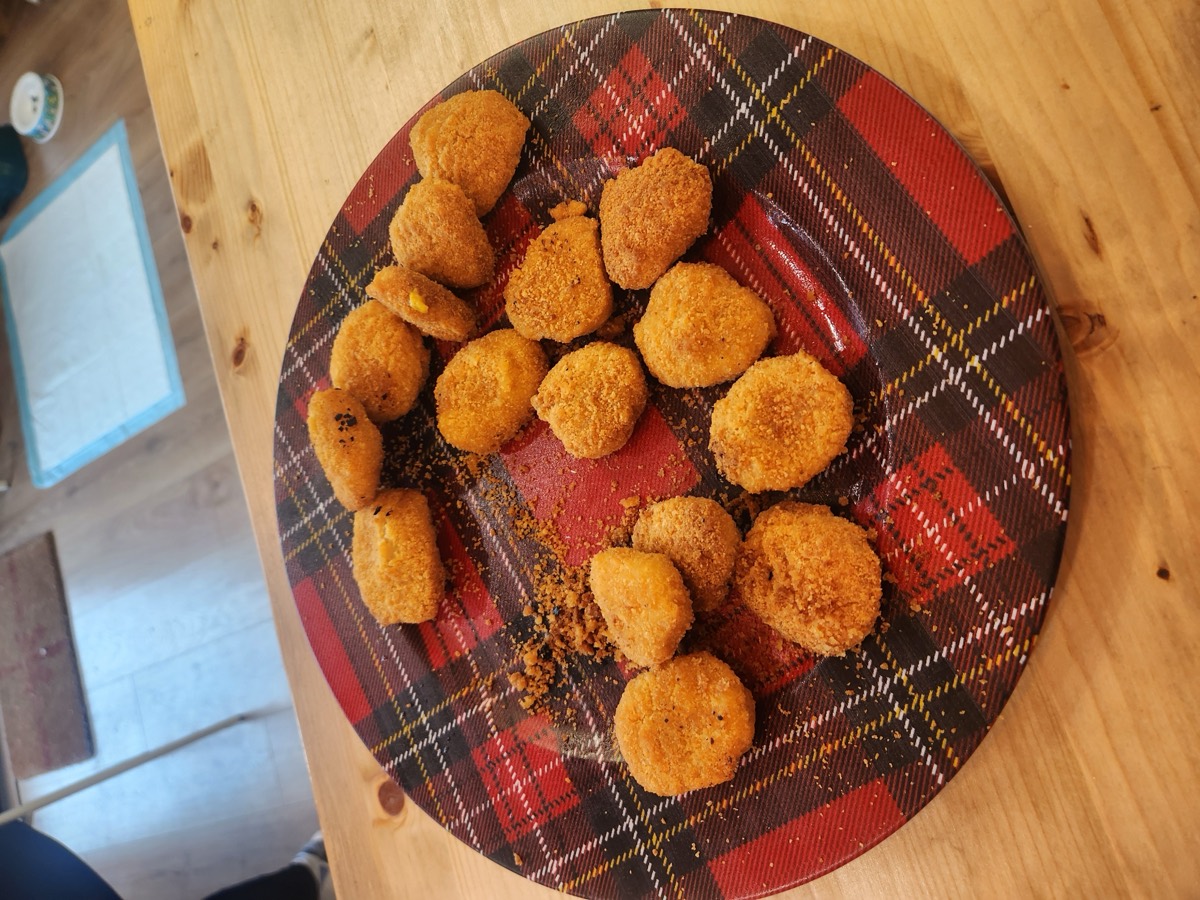 A plaid plate piled with golden fried croquettes