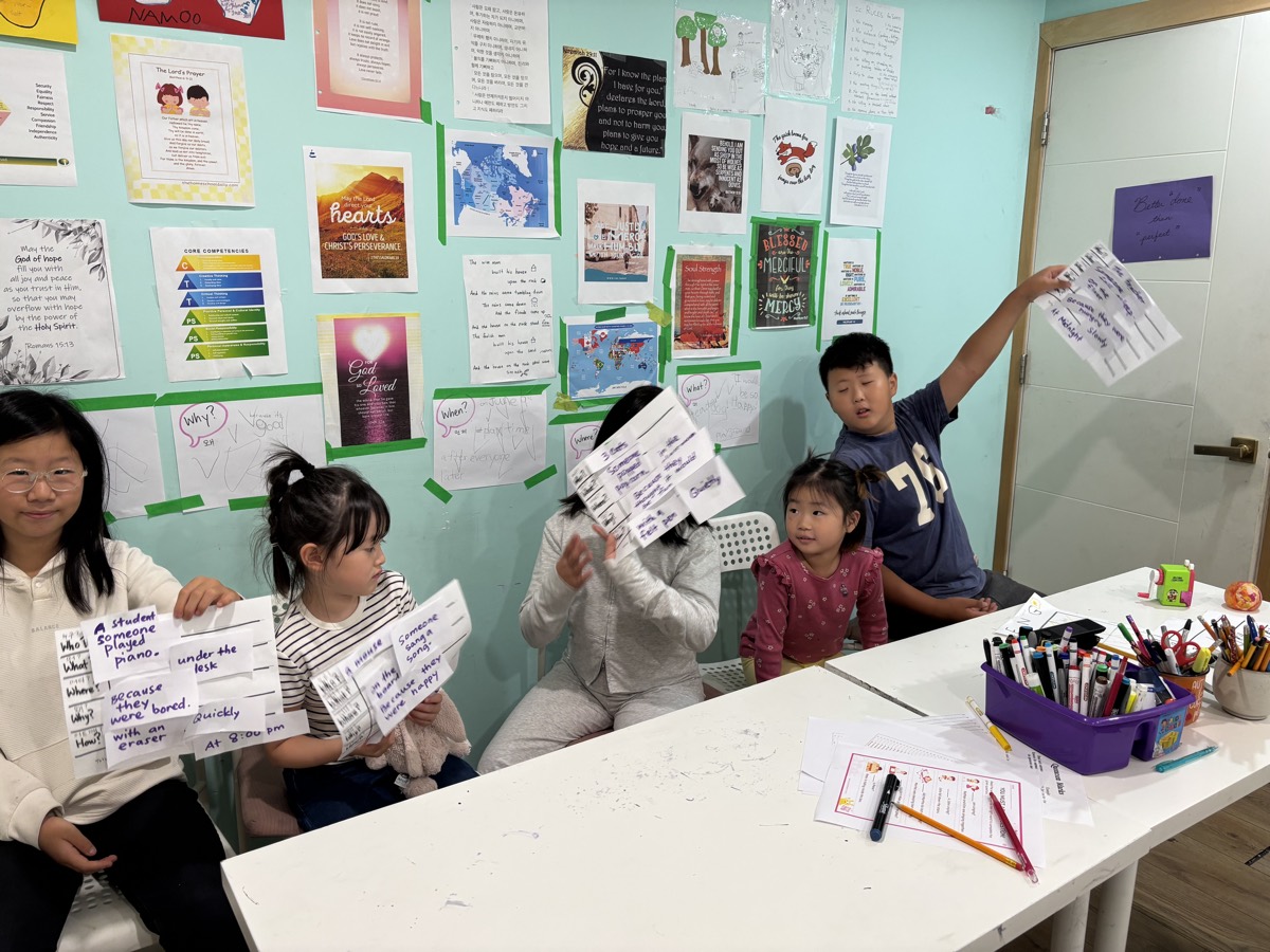 Five students proudly holding up their finished six-question sentence grids