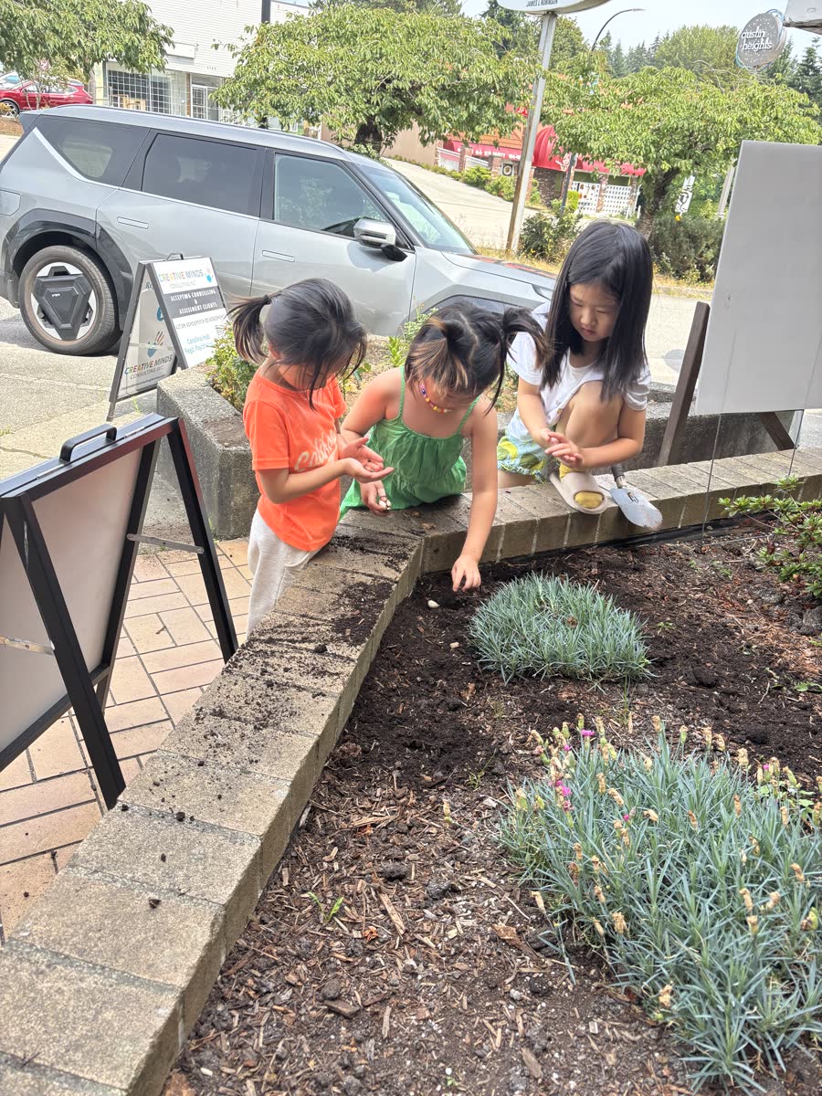Children working together in the garden bed outside the school