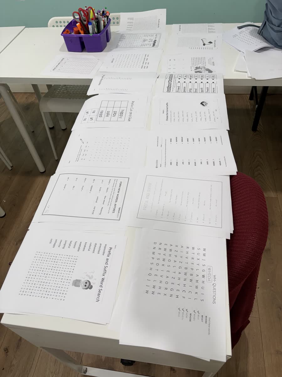 Grammar and vocabulary worksheets spread across a table