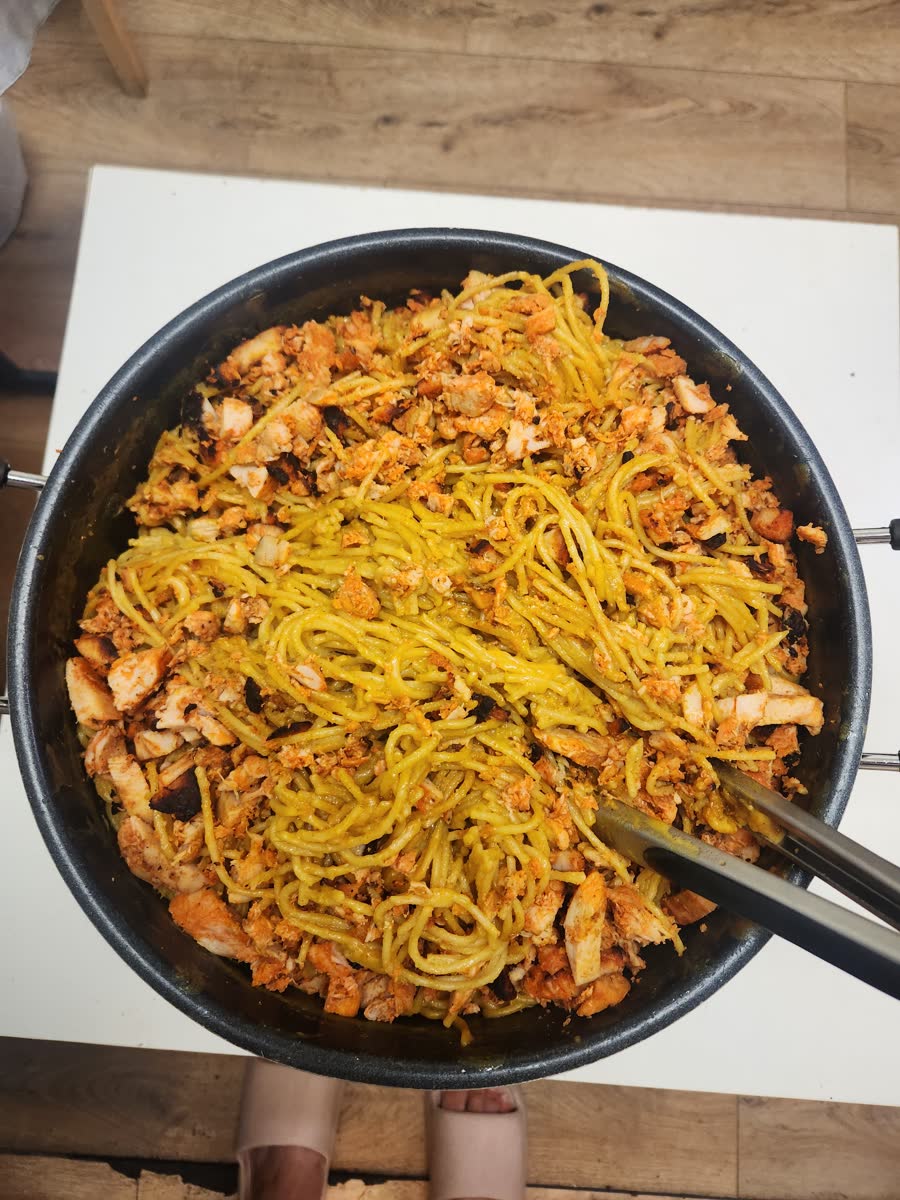 A large pan filled with noodles, rice, vegetables and meat