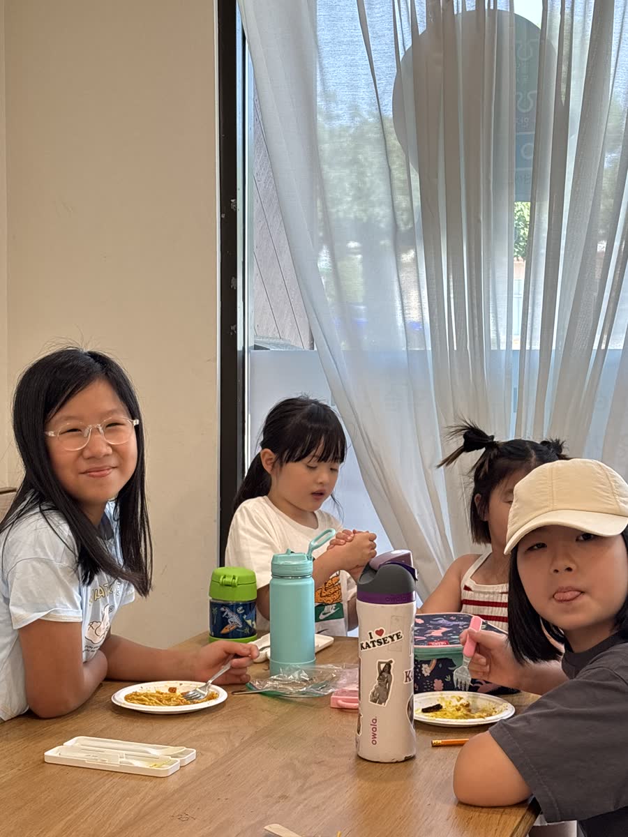 Younger campers eating lunch together around a table