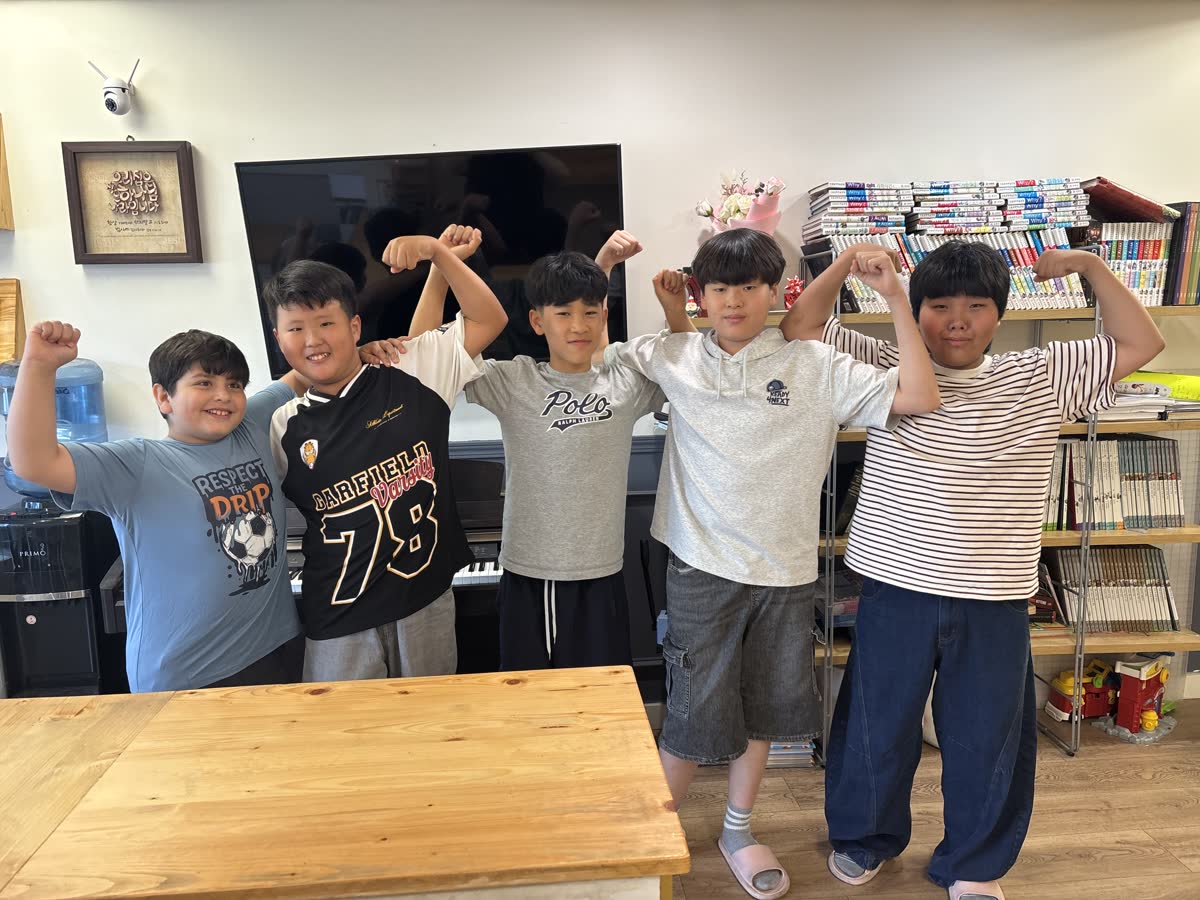 Five older students posing proudly together after the team challenge