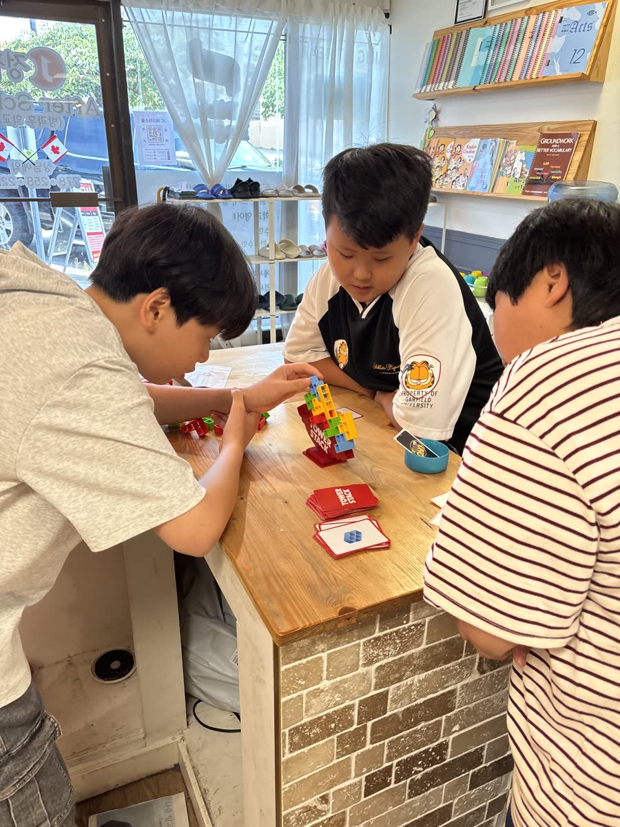 Three older students working together around a colorful UNO card tower