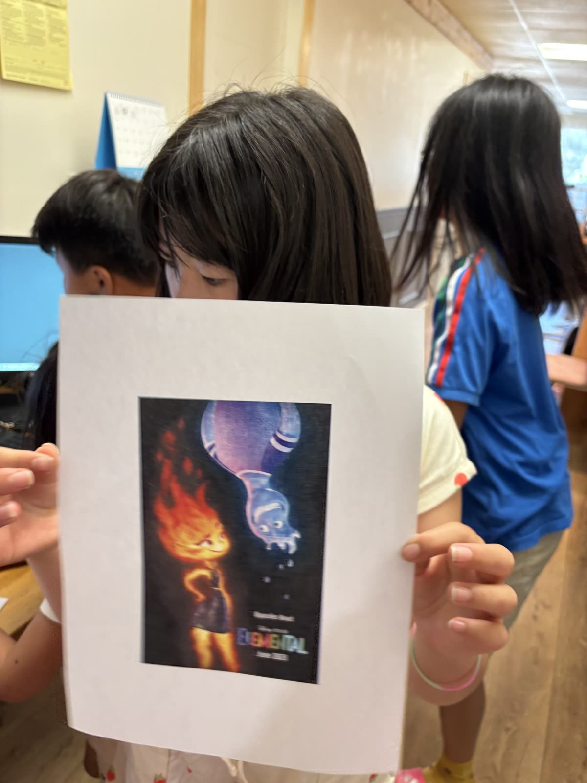 A student holding an Elemental reference image for her project