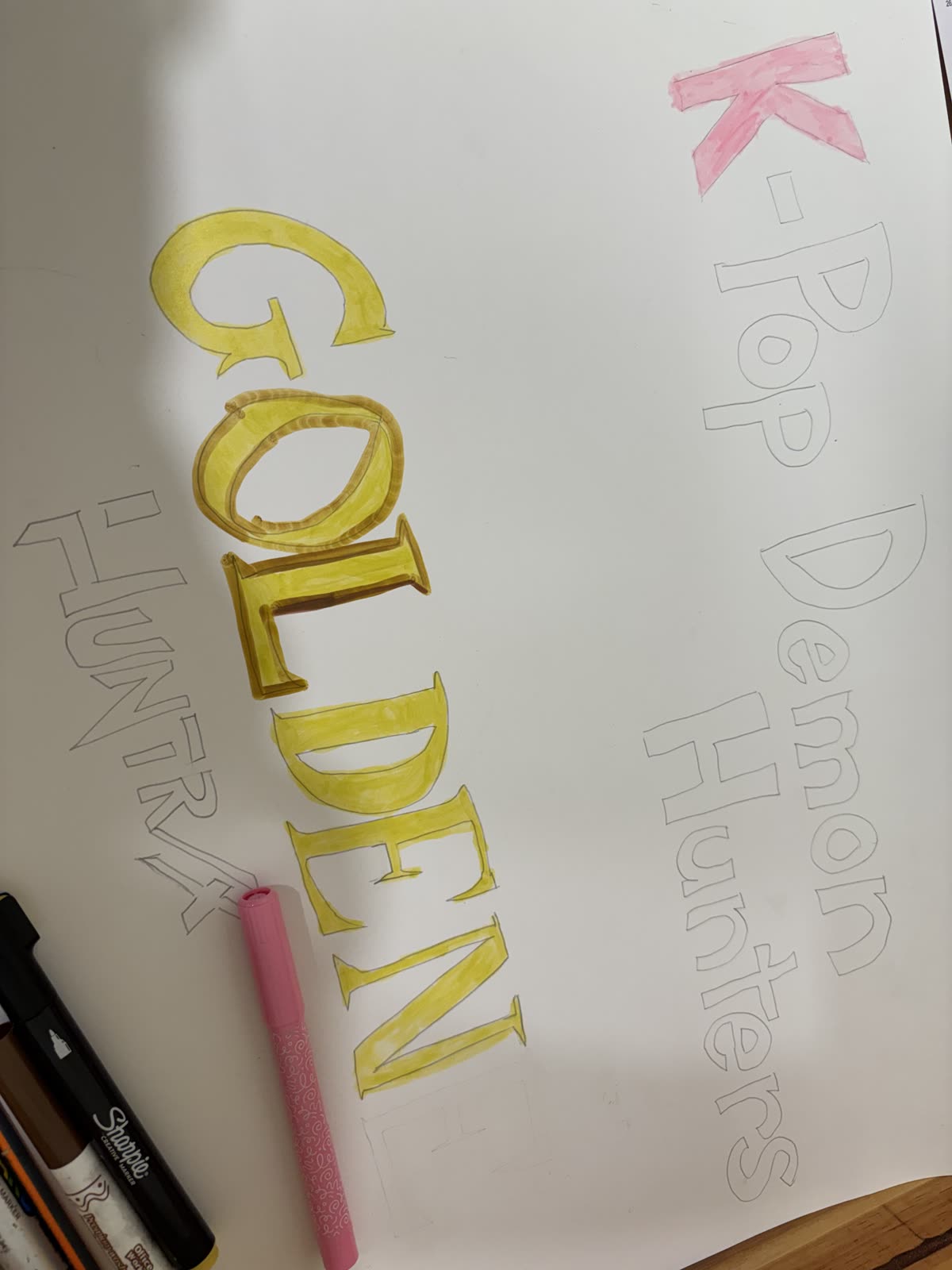 A presentation poster in progress with the words K-pop Demon Hunters and Golden