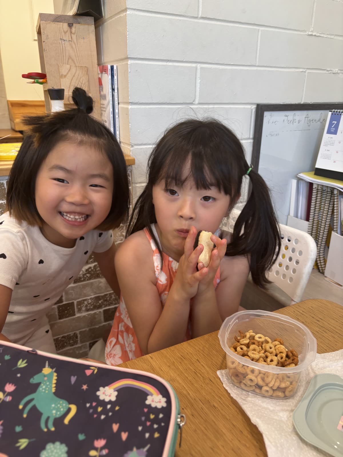 Two young friends smiling together over bowls of snacks