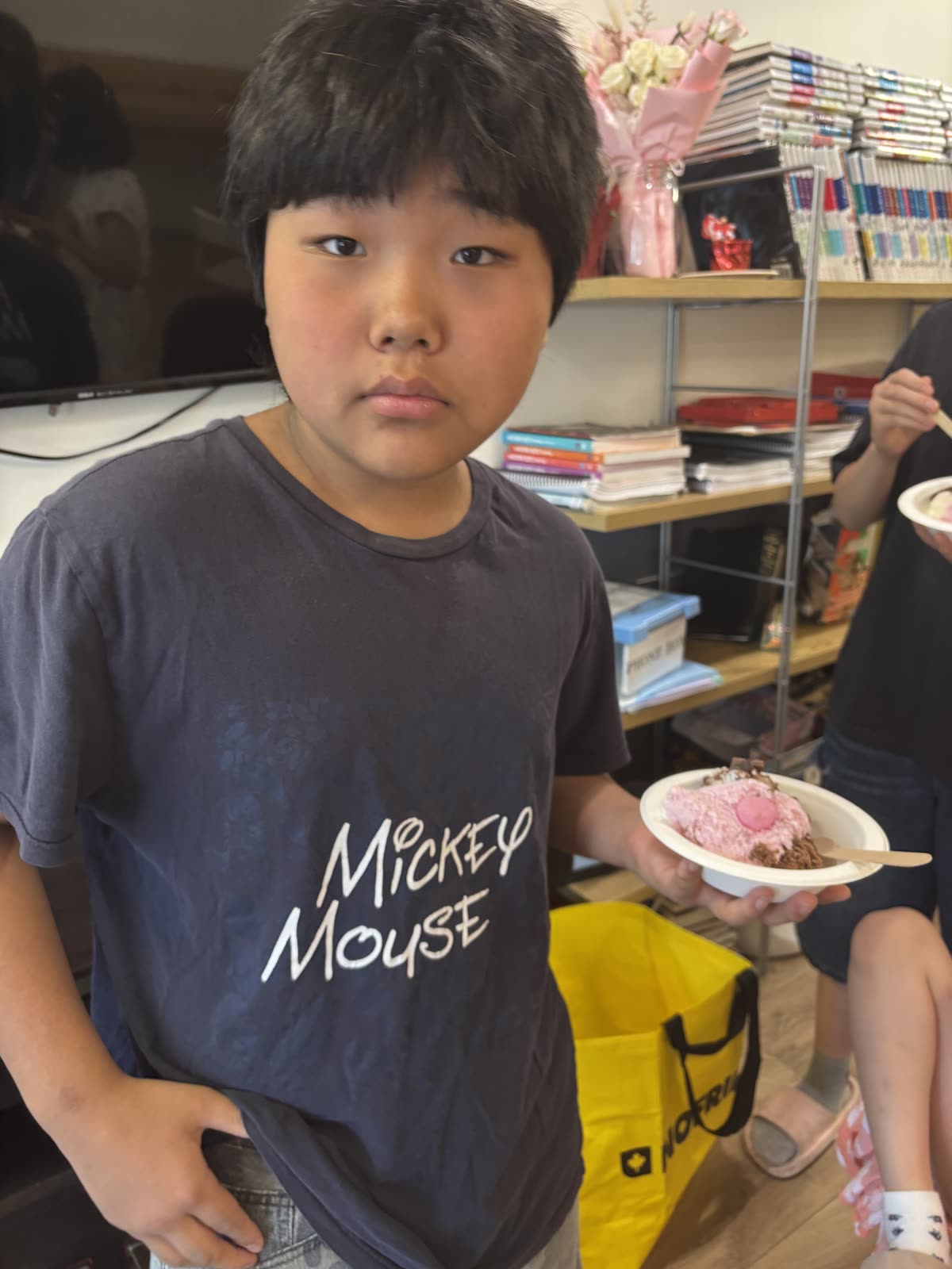 A student holding a bowl of ice cream with colorful toppings