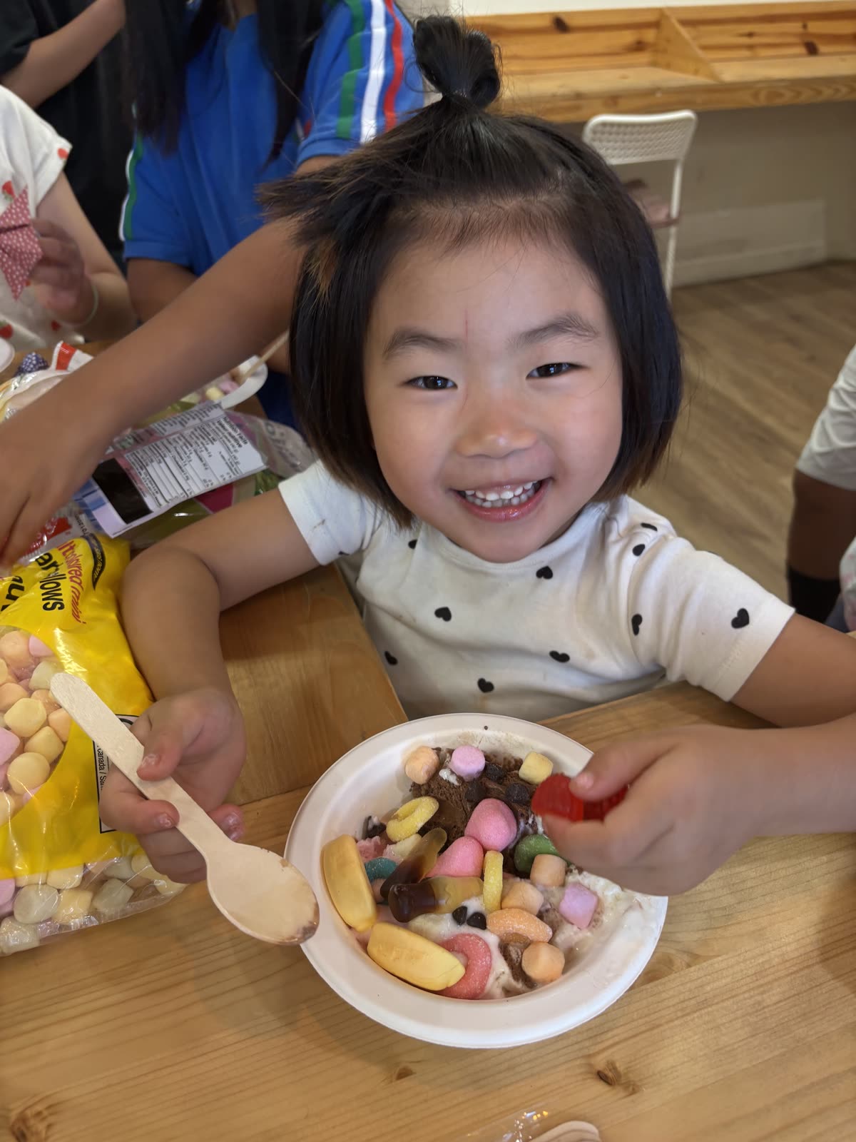 A smiling young student showing her ice-cream sundae
