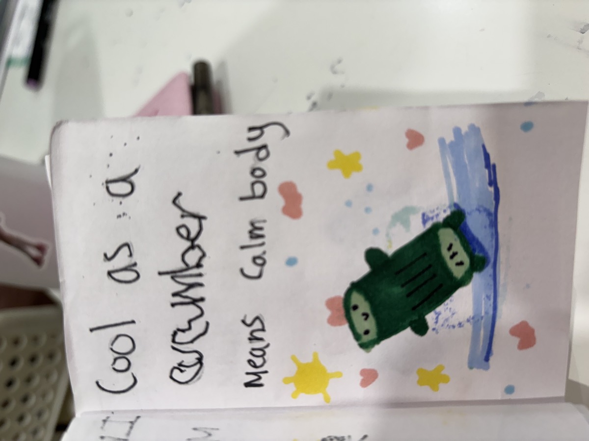 A booklet page reading Cool as a cucumber means calm body, with a drawing of a green cucumber