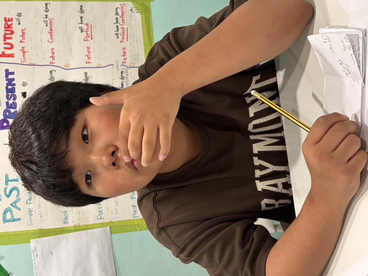 A student pausing with a pencil in hand, thinking about which idiom to write next