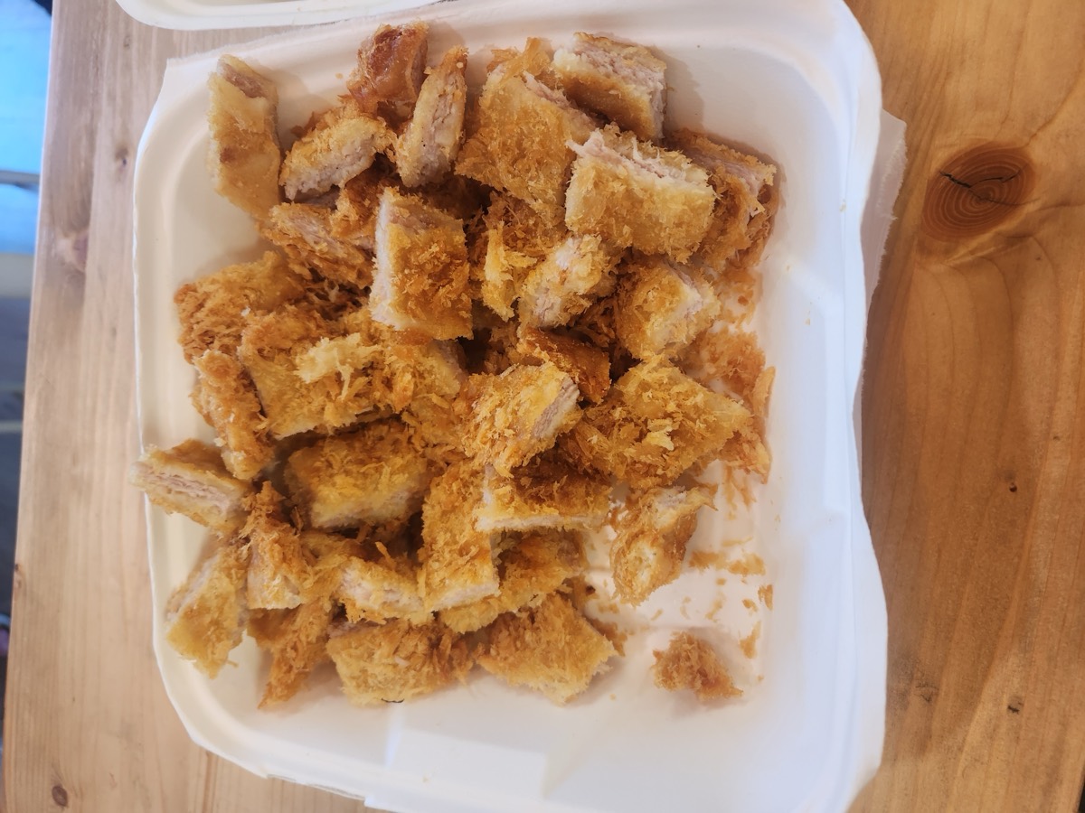 A tray of golden crispy pork cutlet cut into bite-size pieces