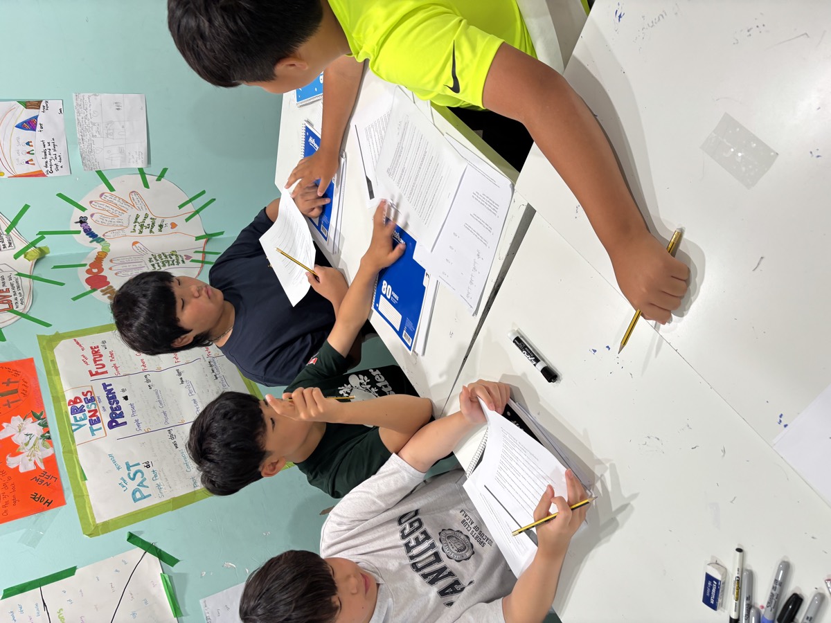 Middle school students working through math problem-solving worksheets at the table with pencils in hand
