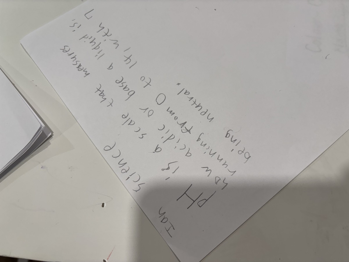 A large sheet of paper with the day's dictation about pH written out by hand