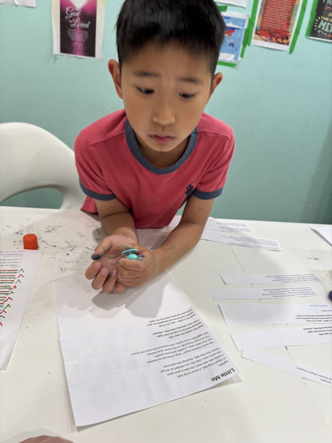 A student working through the 'Little Mo' Moses song lyric sheets at his desk