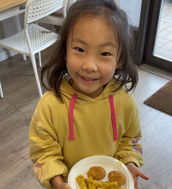 간식이 담긴 접시를 들고 웃으며 서 있는 아이