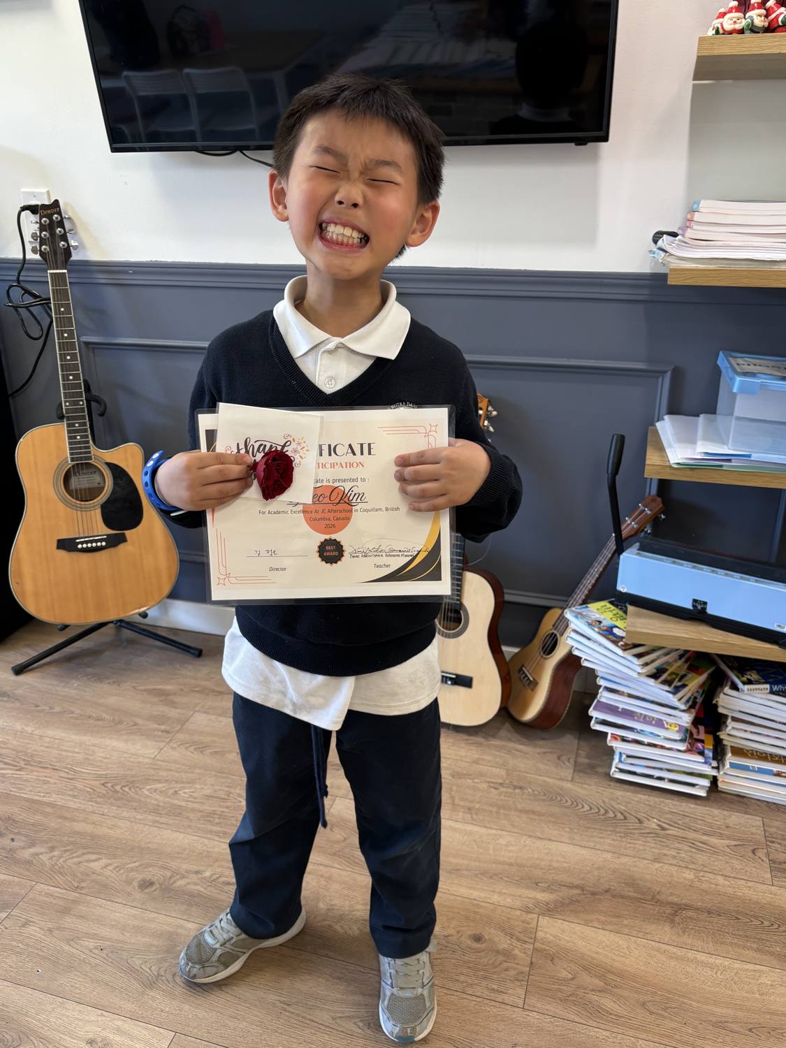 Theo grinning while holding his Certificate of Participation